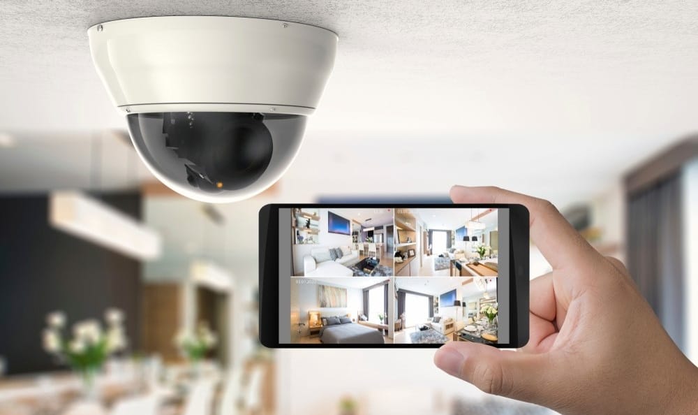 Person monitoring home security system with smartphone