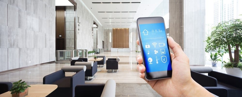 Person with smartphone controlling smart building appliances