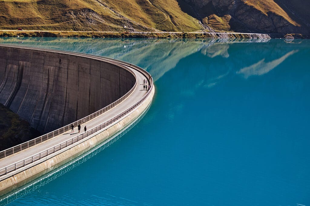 people walking on a dam near water reservoir